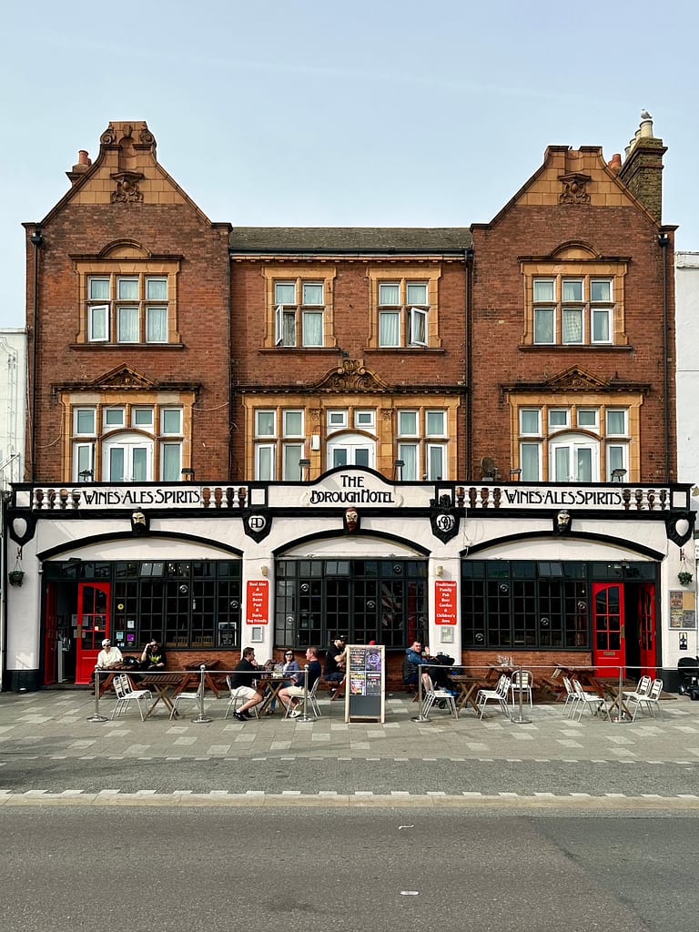 The Borough Hotel along Marine Parade in Southend on Sea, with customers enjoying beverages on the benches out front