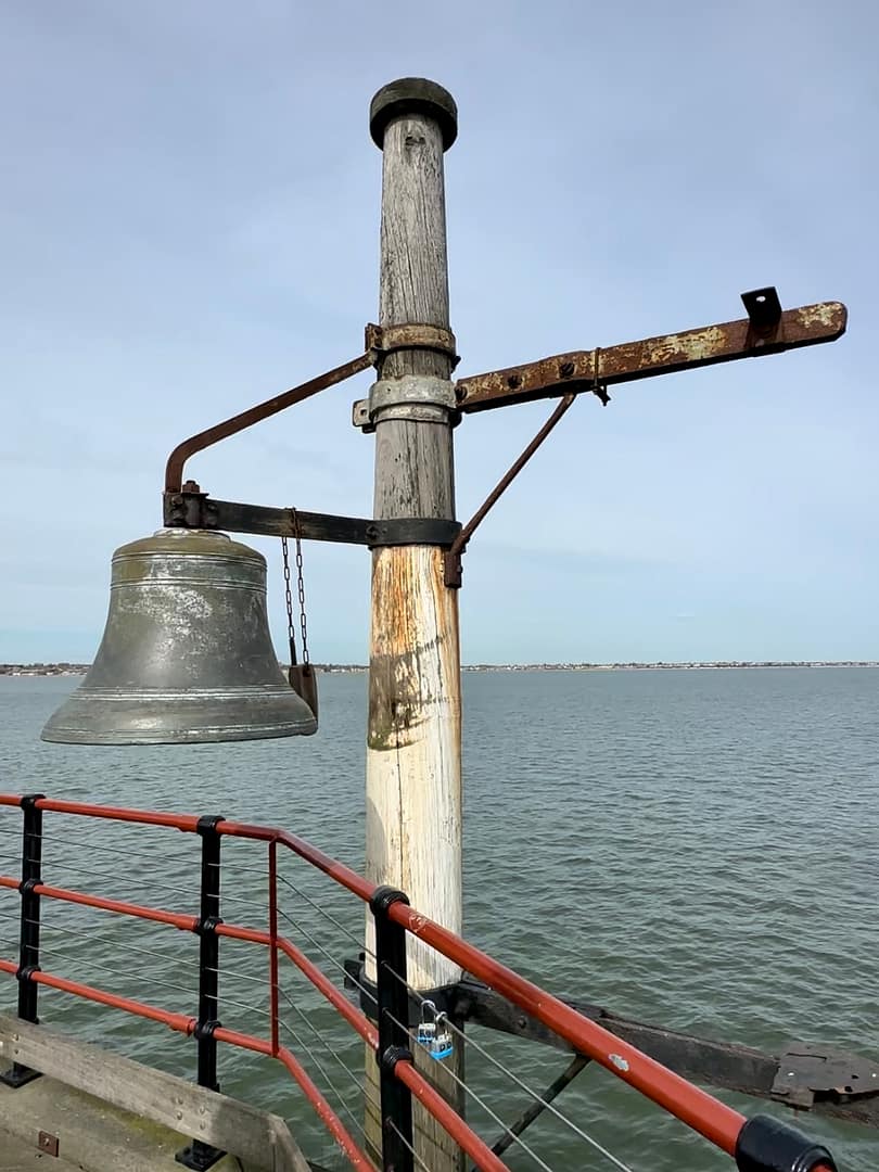 The warning bell at Pier's Head, Southend Pier, with the Thames Estuary in the background